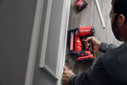 Photo of Craftsman CMCN623C1 cordless nailer used for installing baseboard trim on a wood floor.