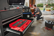 A CRAFTSMAN tool chest with an open drawer containing a red tray of socket wrenches and tools is shown in a garage. In the
